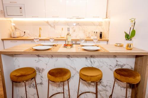 een keuken met een aanrecht met 3 barkrukken bij Luxueux 3p. Art Deco + Parking in Cannes