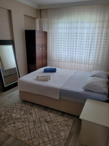 ein Schlafzimmer mit einem großen Bett und einem Spiegel in der Unterkunft Deniz Manzaralı in Arsin