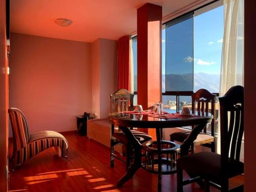 a dining room with a table and chairs and a window at El Peregrino Apart Hotel in Abancay