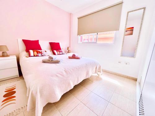 um quarto branco com uma cama grande e almofadas vermelhas em !!! Relaxing View, The Heights Apartment With Terrace and Heated Pools, Los Cristianos em Los Cristianos