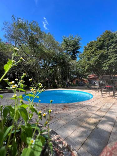 a swimming pool in a yard with trees at Hotel Pousada Cata Branca in Itabirito