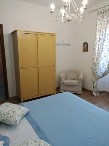 a bedroom with a bed and a yellow cabinet at La Pomella in Ponte Nizza