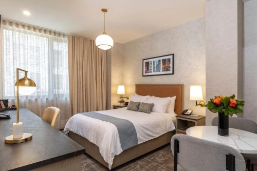 a hotel room with a bed and a desk at Broadway Plaza Hotel in New York