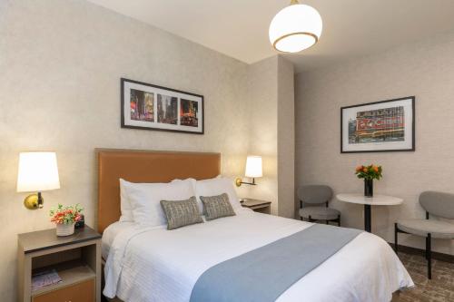 a hotel room with a bed and a table and chairs at Broadway Plaza Hotel in New York