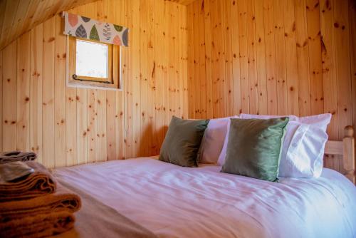 1 dormitorio con 1 cama en una pared de madera en Barnhorn Glamping en Hooe