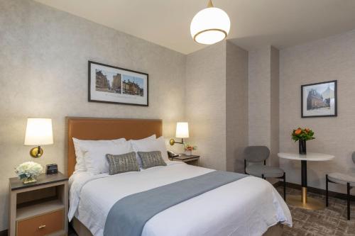 a hotel room with a bed and a table and chairs at Broadway Plaza Hotel in New York