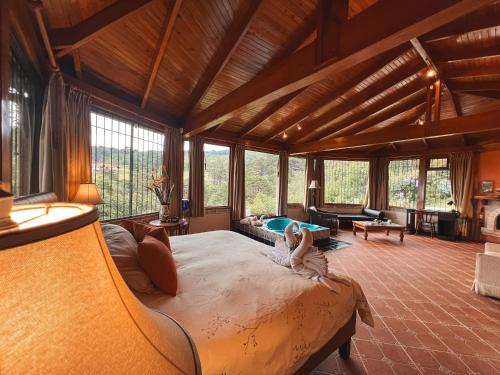 ein Schlafzimmer mit einem großen Bett in einem Zimmer mit Fenstern in der Unterkunft Finca Paraiso Mountain Retreat near San Jose Airport in Birrí