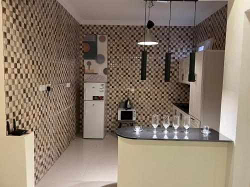 a kitchen with a counter with wine glasses on it at روعة بيتك306 in Riyadh