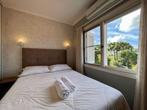 Un pat sau paturi într-o cameră la Apartamentos Solar da Colina CENTRO by Achei Gramado