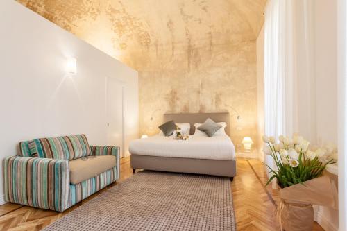 a bedroom with a bed and a chair at 504 Corso Suites in Rome