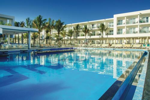 a large swimming pool in front of a hotel at Riu Reggae - Adults Only - All Inclusive in Montego Bay