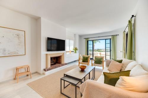 a living room with a couch and a fireplace at VACATION MARBELLA I Aldea Blanca, Luxury Duplex, Sea View, Walking Distance to Puerto Banus in Marbella
