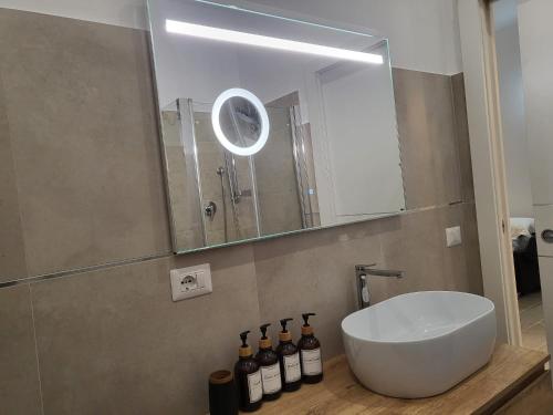 La salle de bains est pourvue d'un lavabo blanc et d'un miroir. dans l'établissement Loft Delle Scalette, à Nepi