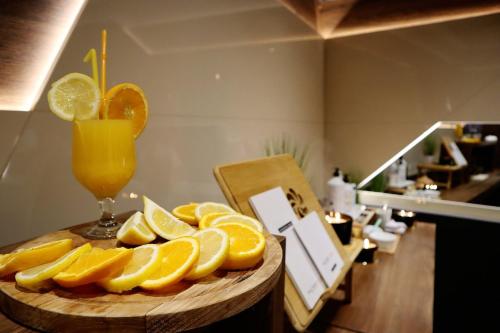 a plate of lemons and a glass of orange juice at Garni Hotel Boutique 25h in Niš