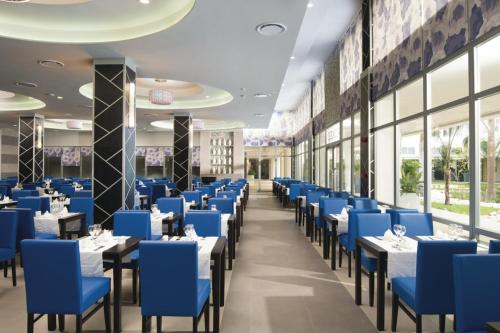 a dining room with blue chairs and tables at Riu Reggae - Adults Only - All Inclusive in Montego Bay