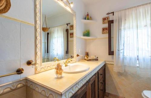 a bathroom with a sink and a large mirror at Casa la serena in Iznájar