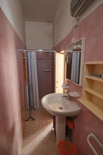 een badkamer met een witte wastafel en een douche bij Casa vacanza Soletina a Soleto cuore del Salento in Soleto