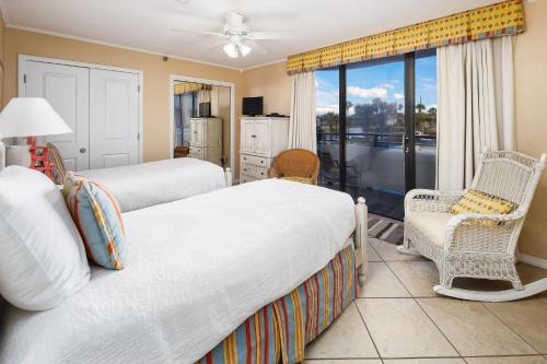 a bedroom with two beds and a balcony at Nautilus 1201 - Gulf Front 2 Bedroom Huge Wrap Around Balcony 2nd Floor! Free Beach Service 3/1-10/31 in Fort Walton Beach