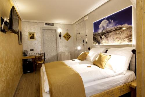 a bedroom with a large white bed with a painting on the wall at Boutique Hotel Sierra de Alicante in Busot