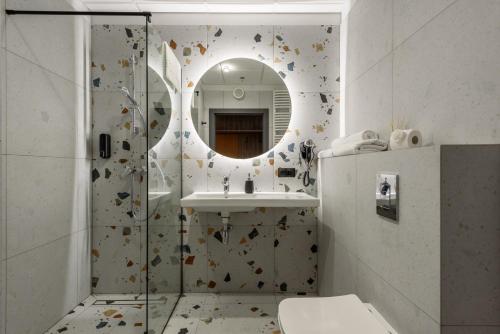 ein Bad mit einer Dusche, einem Waschbecken und einem Spiegel in der Unterkunft Kasprzaka 29-929 - EXTRA VIEW - 10 kondygnacja in Warschau