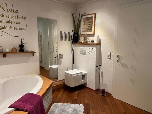 a bathroom with a bath tub and a toilet at Haus Berger in Fuschl am See