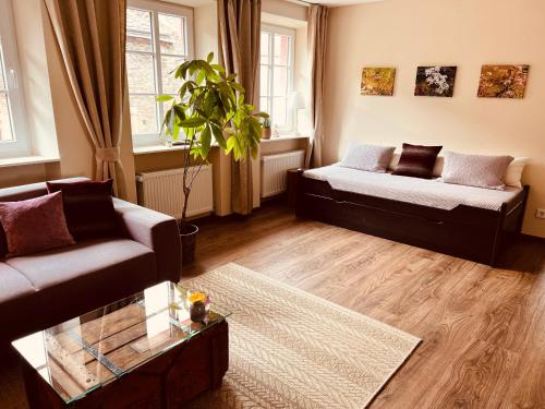 a living room with two couches and a plant at Alte Schmiede zu Trarbach in Traben-Trarbach
