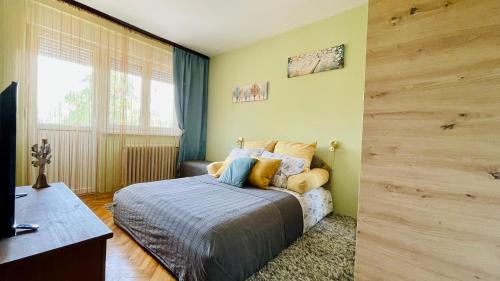 um quarto com uma cama, uma secretária e uma janela em Apartman Jelena II em Sremska Mitrovica