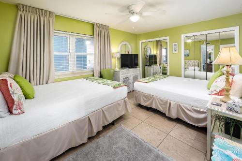 two beds in a room with green walls at Nautilus 1203 - Gulf Front 2 Bedroom! 2nd Floor! Free Beach Service March to October in Fort Walton Beach