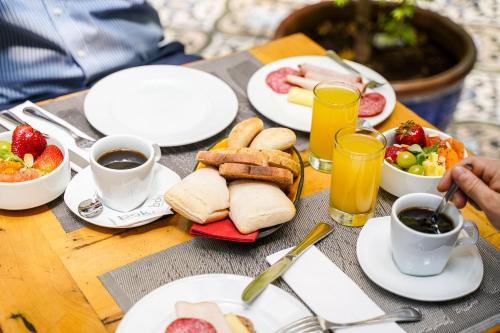 a table with plates of breakfast foods and drinks at Time Select - Elegant Apartments in Santiago