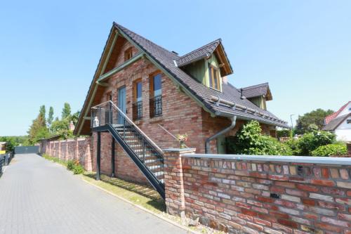a brick house with a staircase on a brick wall at Am Rieck "Fachwerkaus" in Zempin