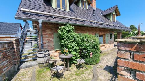 een stenen huis met een tafel en stoelen in de tuin bij Am Rieck "Fachwerkaus" in Zempin