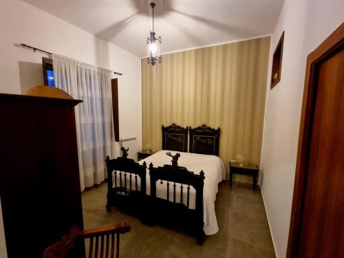 ein Schlafzimmer mit einem schwarzen Bett und einem Fenster in der Unterkunft Hostaria Zerø HR in Piedimonte dʼAlife
