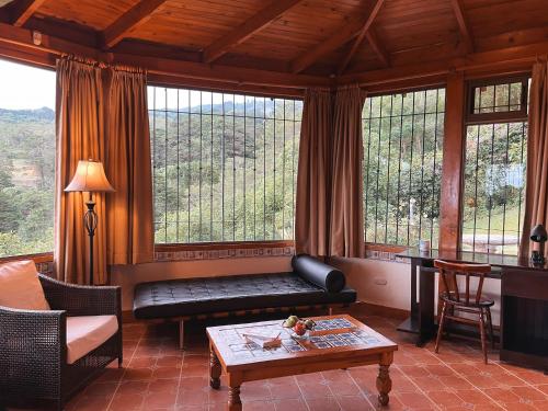 a living room with a couch and a table at Finca Paraiso Mountain Retreat near San Jose Airport in Birrí
