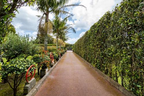 a walkway through a garden with trees and plants at Quinta da Paz Azores in Pico da Pedra