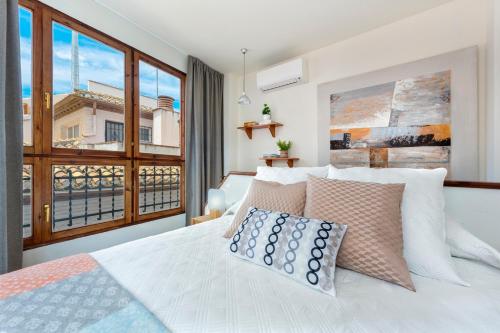 - une chambre avec un lit blanc et une grande fenêtre dans l'établissement Genteel Home Piedra Santa, à Grenade