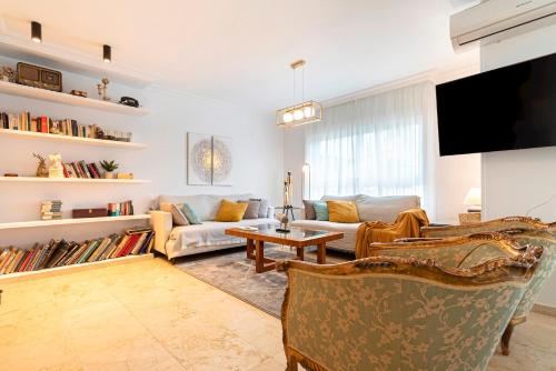 ein Wohnzimmer mit einem Sofa und einem TV in der Unterkunft Genteel Home Martinez Campos in Granada