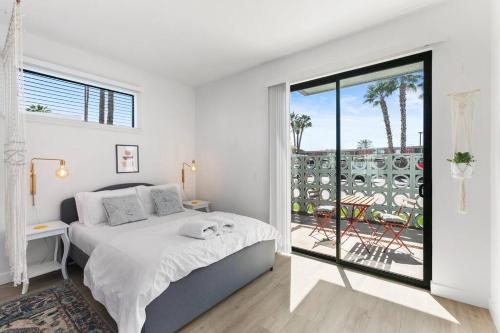 a white bedroom with a bed and a balcony at Large Studio Rooftop & Poolside - Walk to Old Town in Scottsdale