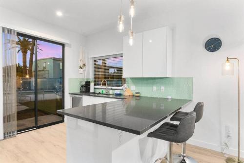 a kitchen with a counter and chairs in it at Large Studio Rooftop & Poolside - Walk to Old Town in Scottsdale