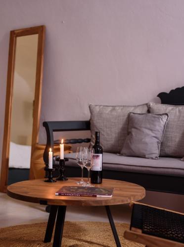 a living room with a table with two candles and wine glasses at Firalia, Casa in Rock Suites in Fira