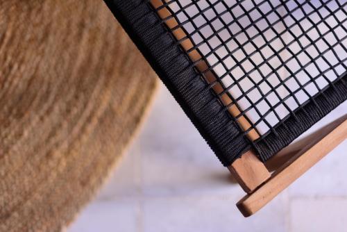 a close up of a wooden bench with rattan at Firalia, Casa in Rock Suites in Fira