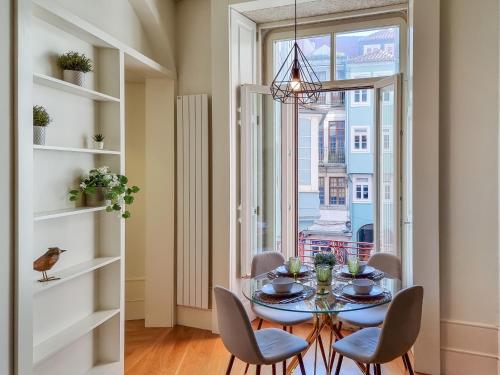 d'une salle à manger avec une table, des chaises et une fenêtre. dans l'établissement Inspiring City Center 1BR Apartment, à Porto