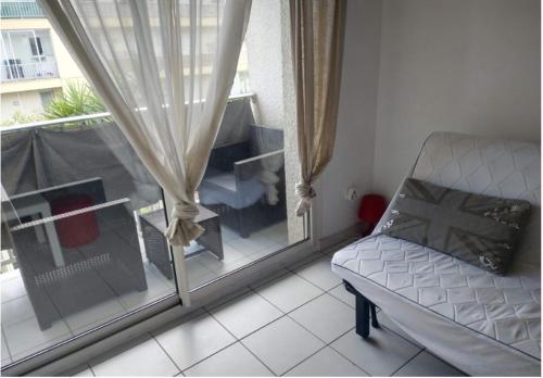 ein Wohnzimmer mit einem Sofa und einem Fenster in der Unterkunft PALAVAS STUDIO AVEC BALCON ET PARKING in Palavas-les-Flots