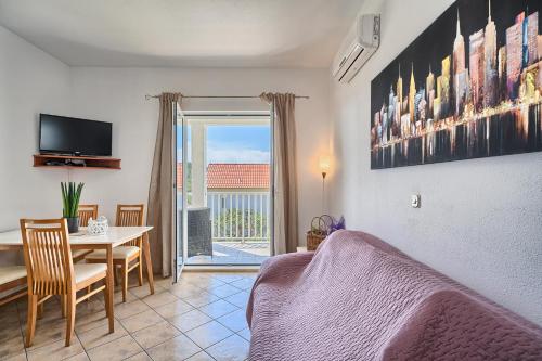 Sala de estar con mesa de comedor y TV en Apartments Irena, en Hvar