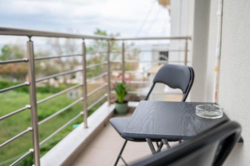een zwarte stoel op een balkon met een tafel bij The View in Alexandroupoli