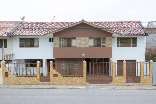 a house with a fence in front of it at Cozy & Spacious House-Near the Centro in Cuenca