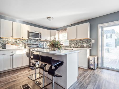 a kitchen with white cabinets and a counter with stools at VISTA A-A in Washington, D.C.