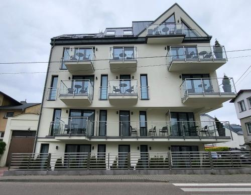 a tall white building with balconies on it at Baltic Soul Villa in Międzyzdroje