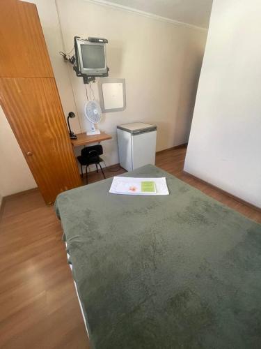 a room with a bed and a tv and a desk at Hara Palace Hotel in Curitiba