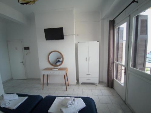 Habitación blanca con cama y espejo en Omiros rooms, en Chios