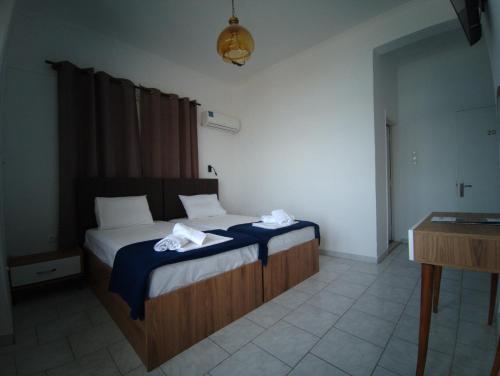 een slaapkamer met een bed met twee handdoeken erop bij Omiros rooms in Chios